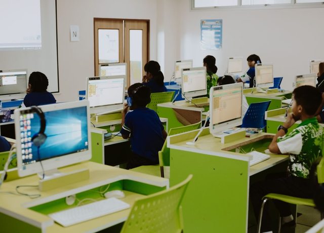 Students learning at computers in a bright, modern computer lab